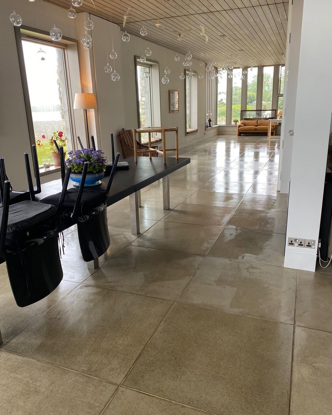A cleaner using a machine to clean tiles on a floor