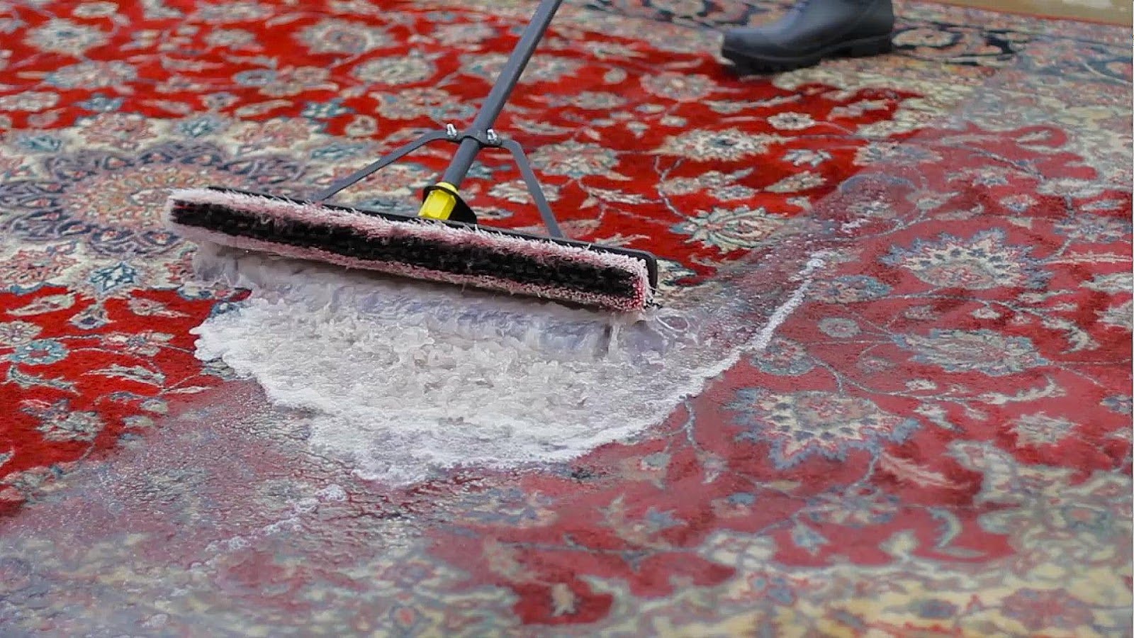 oriental rug getting a deep clean using water and a brush